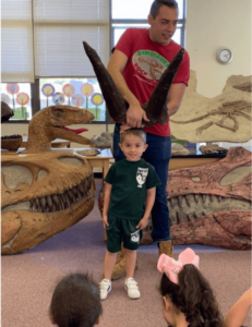 Birthday child demonstrates what Triceratops Horns Look Like at a Dinosaurs Rock Birthday party