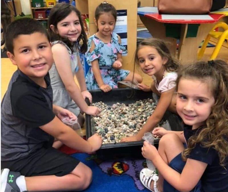 5 young kids digging for fossils and minerals at a school event