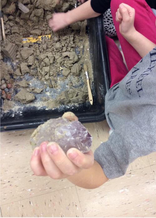 child-showing-amethyst-crystal-found-in-excavation-block