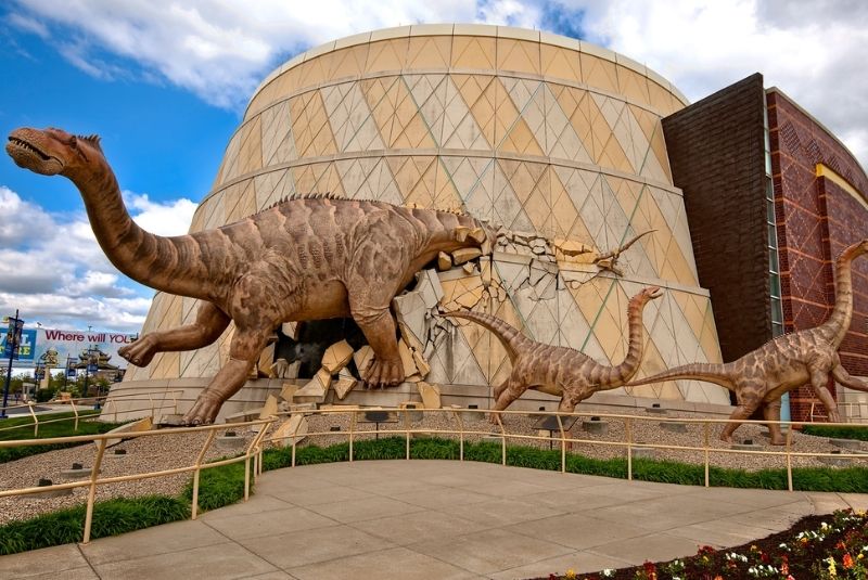 The Children's Museum of Indianapolis showing the outside of the building with several dinosaur sculptures outside